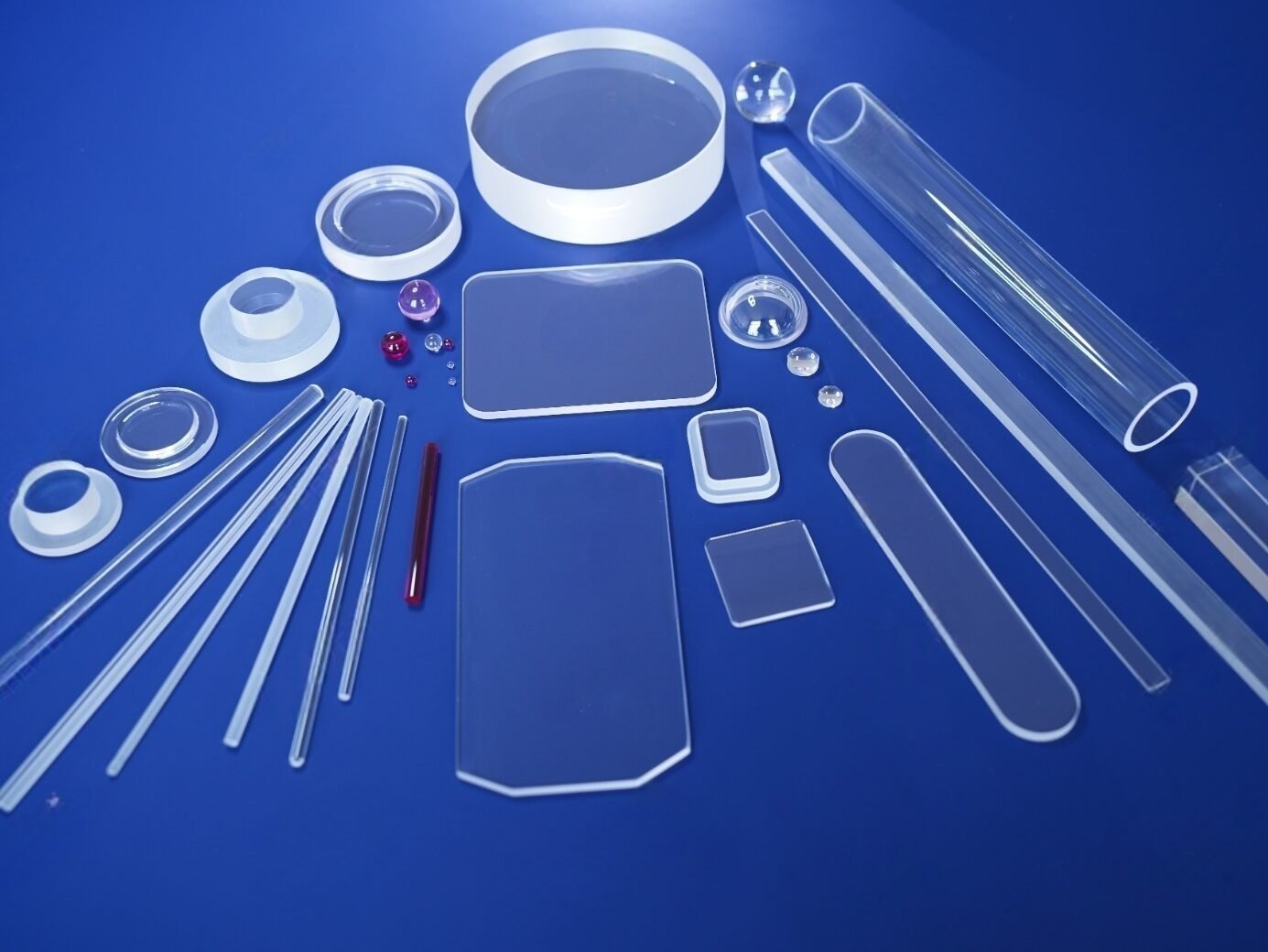 A collection of polished synthetic sapphire components in various shapes